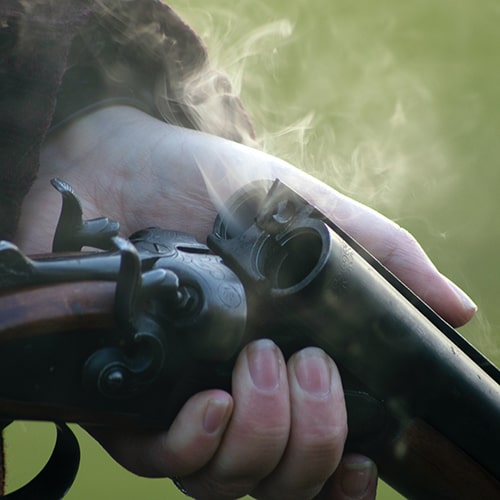 Photo of someone holding open a smoking double-barrel shotgun chamber - William Isted on Unsplash
