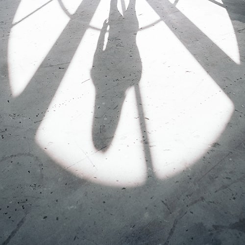Photo of a woman's shadow in the shadow of a semicircular window - Kevin Wolf on Unsplash
