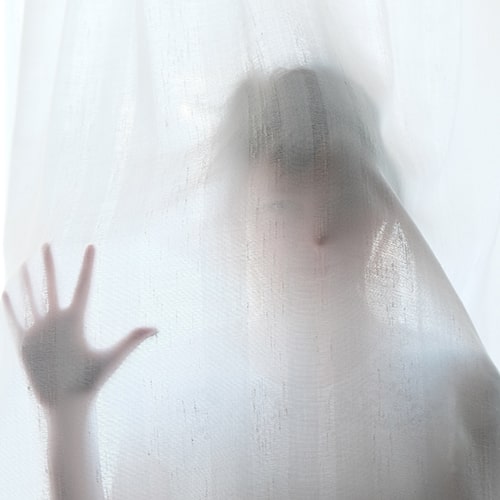 Photo of a woman standing behind a sheer white cloth - Steinar Engeland on Unsplash