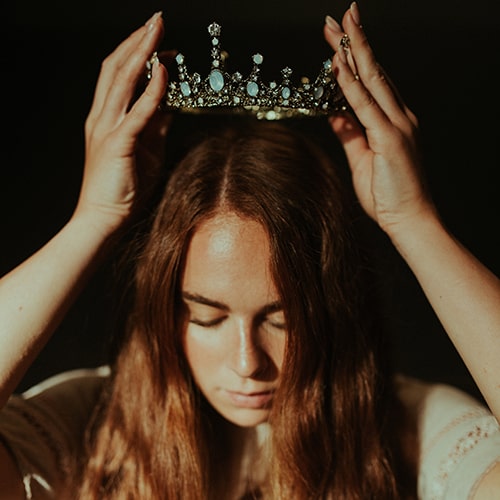 Image of a woman putting a tiara on her head - Jared Subia on Unsplash