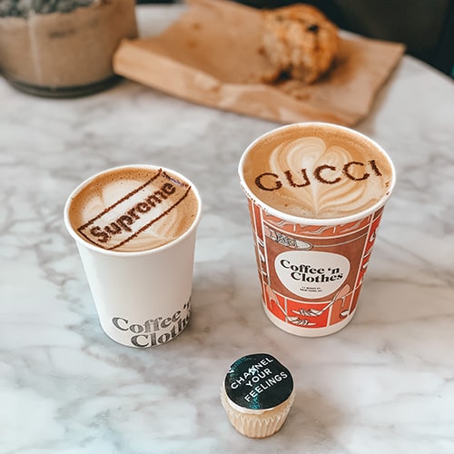 Branded cappucinos with 'Supreme' and 'Gucci' written in the foam.