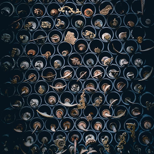 Photo of scrolls stored in a wall of circular holders - Cobro on Unsplash