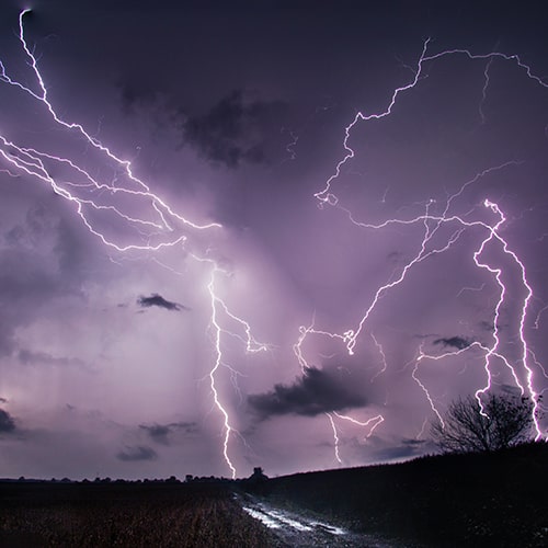 Photo of a stormscape with purple clouds and white, vein lightning - NOAA on Unsplash