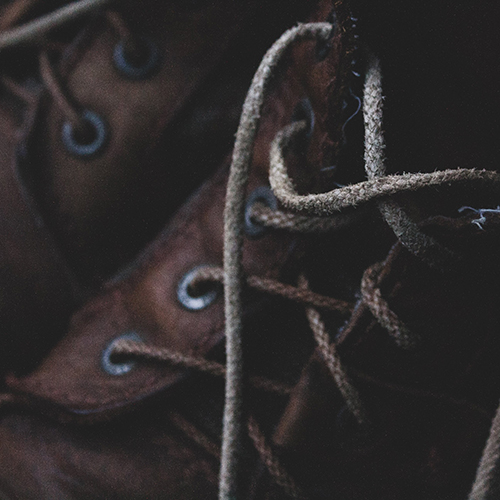 Macro image of a pair of brown boots with taupe-colored laces